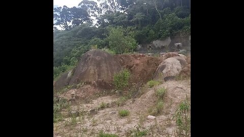 TRECHO DO ESQUELETO DO RODOANEL NORTE TRILHA CERCADA DE MATO E RESTOS DE OBRA E PEDRAS GRANDES