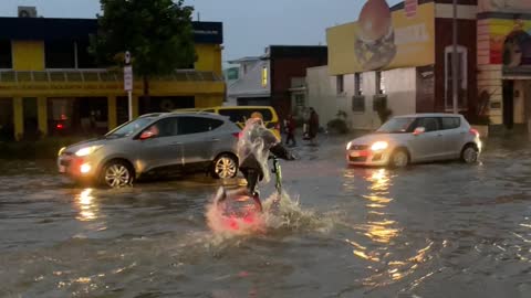 Guys Ride Through Flooded Streets on Electric Scooters