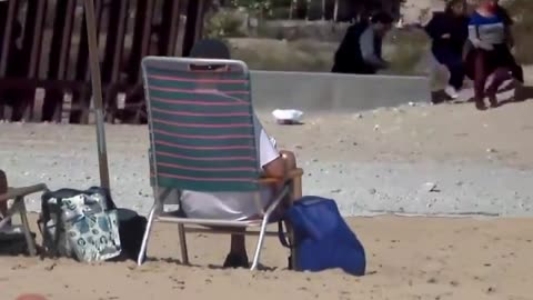 Crooked Joe vacations on the beach 🏖️ while they flood into the country 🌊🚶‍♂️