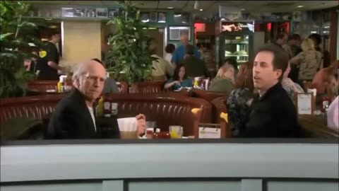 Larry David and Jerry Seinfeld argue over who slides over in the booth.