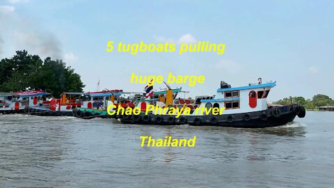 5 tugboats pulling a huge barge at Chao Phraya river in Thailand