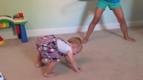 Tot Boy Falls With Laughter While His Sister Spins A Hula Hoop