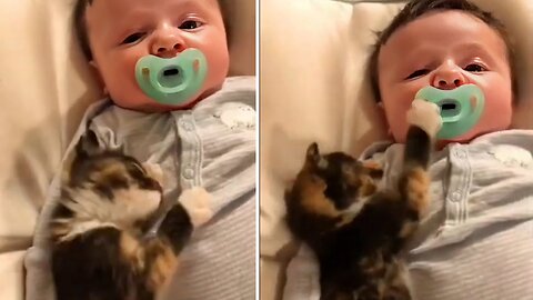 A cute cat is sleeping with a sweet baby.