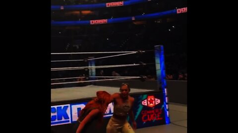 Bianca Belair dragging Becky Lynch over to a fan and letting the fan hit Becky with her braid