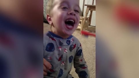 "A Tot Boy Laughs While His Dad Brushes His Teeth"