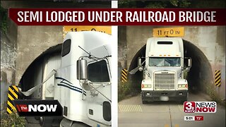 Semi lodged under railroad bridge