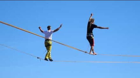 Slackliner performs dangerous trick hundreds of feet above the ground