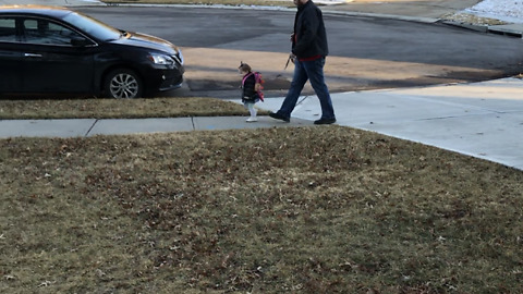 Dad walks his daughter on a leash