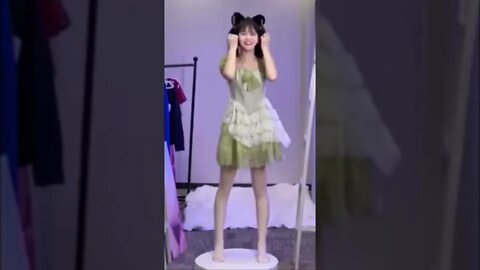 Cute Chinese Girl In Green Cosplay Costume Bounces Up And Down