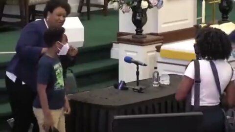 Stacey Abrams asks a child to remove his masks for the photo op session