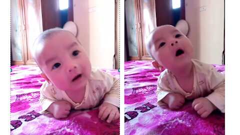 4-month-old baby waiting to tell a story with her mother