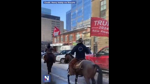 A man on horseback waves a 'TRUMP 2024' flag