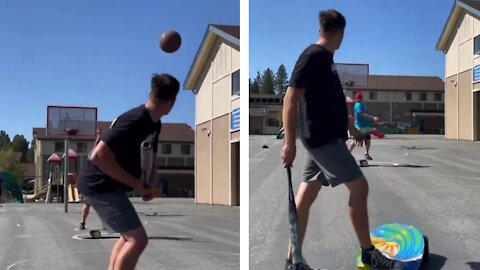 Man Scores Basket by Hitting Ball With Baseball Bat