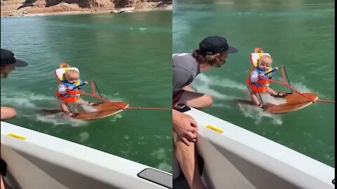 Baby Riding Surfing board on sea