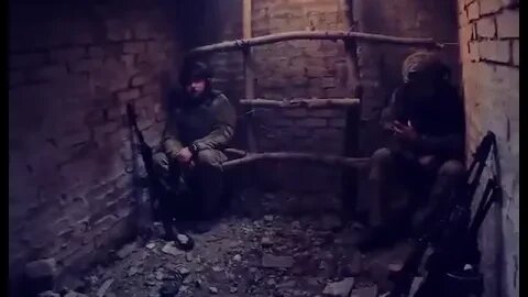 UA soldiers sheltering from artillery fire in a cellar, debris falling through opening