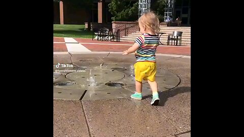 Splash Fun joyful toddler playing with water, their face beaming with excitement as they splash