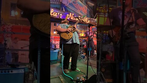 Man drinks beer while playing guitar