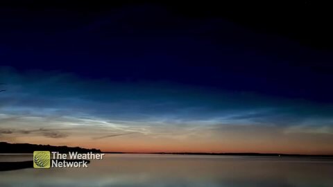 Noctilucent clouds glide across the night sky