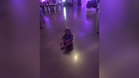 "A Baby Boy Dances to Music at A Wedding While Sitting Down"