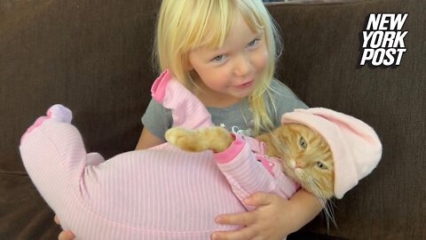 Sweet girl sings lullaby to cat in pajamas