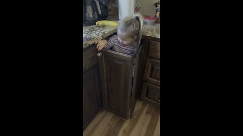 Evie in her cupboard house.