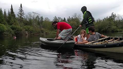 Man Tries To Climb Into A Kayak From A Canoe