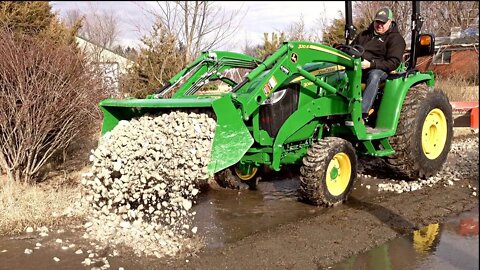 John Deere 3046R First Project, Repair NASTY Driveway with 2 Inch Rock.