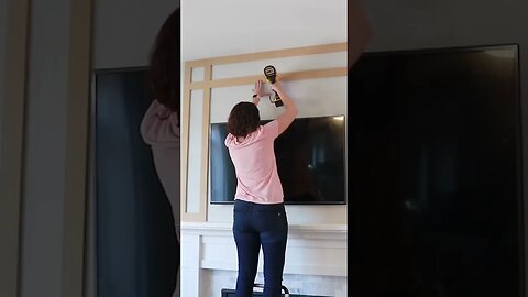 Samantha adding shaker slats to the fireplace wall. #woodworking #diy #shorts