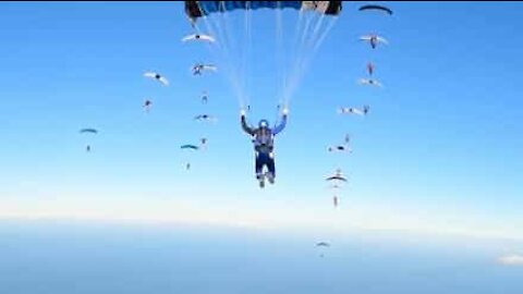 Awesome stunt sees parachutist maneuver between speeding corridor of skydivers