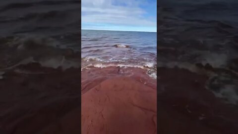 Waves crashing on red sand