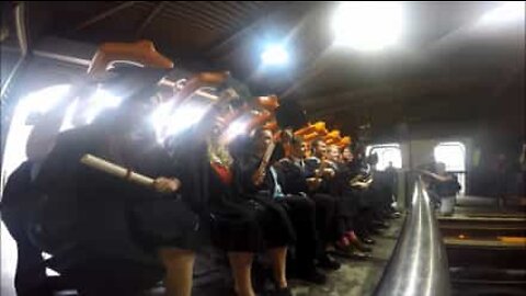 Students celebrate their graduation on a roller coaster