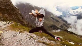 Girl puts on t-shirt while doing handstand