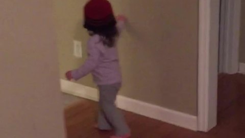 Tot Girl Puts A Beanie Over Her Head And Navigates Around A House