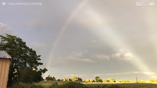 Raggi di sole, fulmini e l'arcobaleno in un unico paesaggio