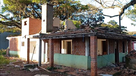 casa de tijolo á vista com laje e sótão abandonada embaixo de uma grande figueira