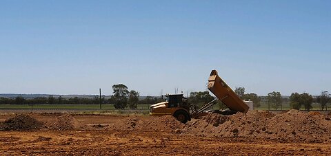 Earthworks for grain storage facility: excavator, articulated dump truck, water truck, bull dozer