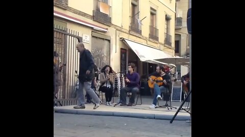 Cantora Rosalía enquanto ela se apresentava na praça enquanto homem da dinheiro pra ela