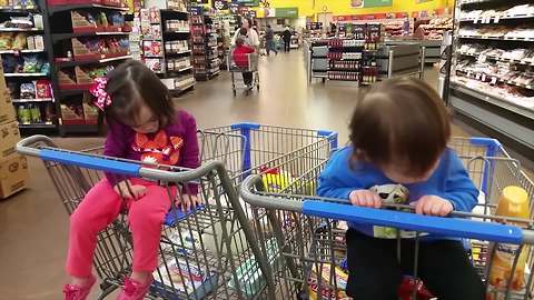 "A Tot Boy And Tot Girl Both Fall Asleep In Shopping Carts In A Store"