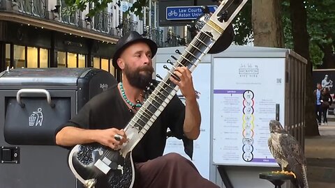 busker playing the Indian sitar .