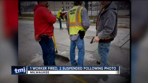 One fired, two suspended after armed workers photo surfaced