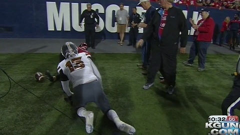 Arizona Wildcats quarterback runs over Miss Arizona on sideline during game