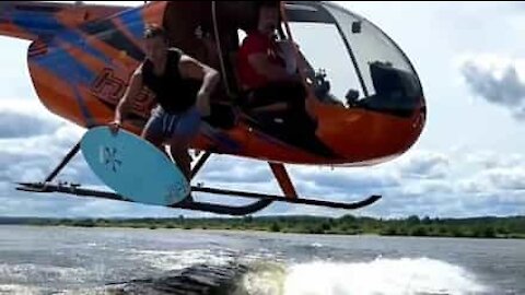 Surfer jumps from helicopter with his board