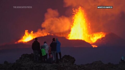 Northern lights shine in night sky as lava spews from erupting volcano in Iceland