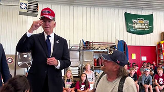 Full exchange of Biden putting on a Trump 2024 hat: "I don't remember my name, I'm slow." Man: "You're an old fart." Biden: "I need that hat." Crowd: "Put it on!" Man: "I'm proud of you now,