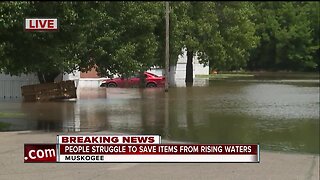 People struggle to save items from rising waters