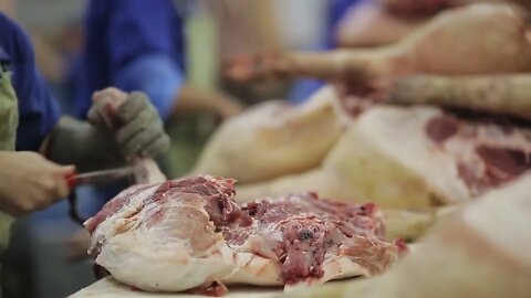 Butcher Cutting Pork Meat in Meat Factory. Fresh raw pork chops in meat factory. Meat processing in