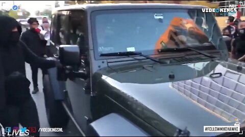 Aggressive ANTIFA-hooligan tries and fails to break car window. | #MillionMAGAmarch