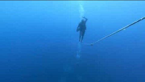 Diver walks tightrope under water