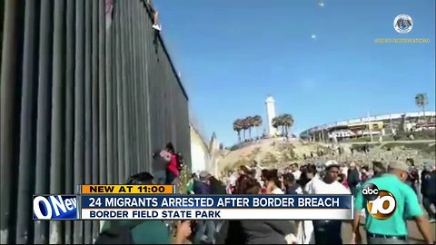 Migrants climb over border fence at Border Field State Park