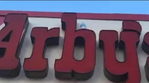 Impossible 'bottle flip challenge' on restaurant entrance sign